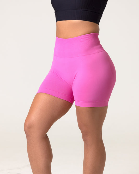 A woman wearing a pink scrunch butt seamless shorts