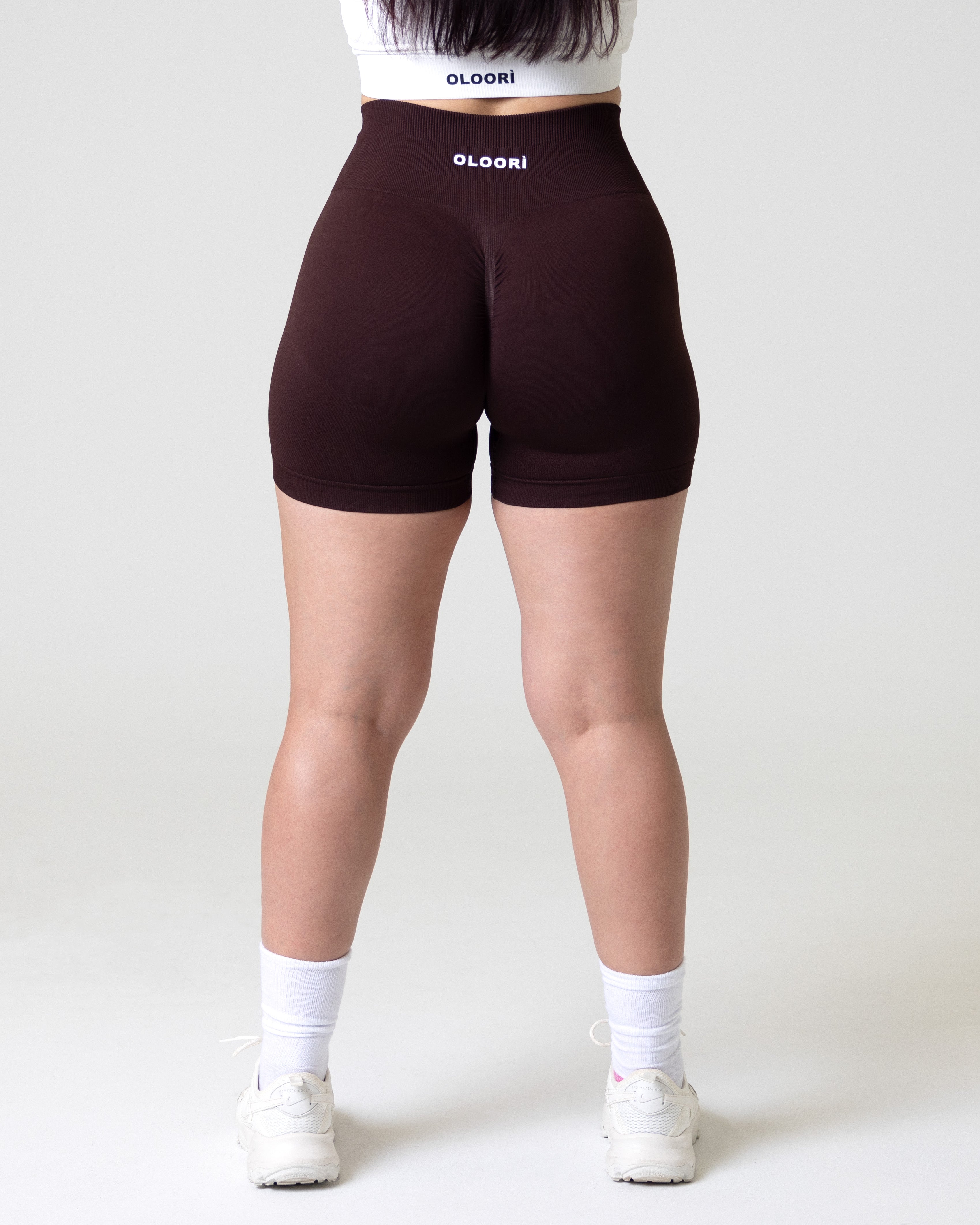 A woman wearing brown sepia elevate seamless fitness shorts