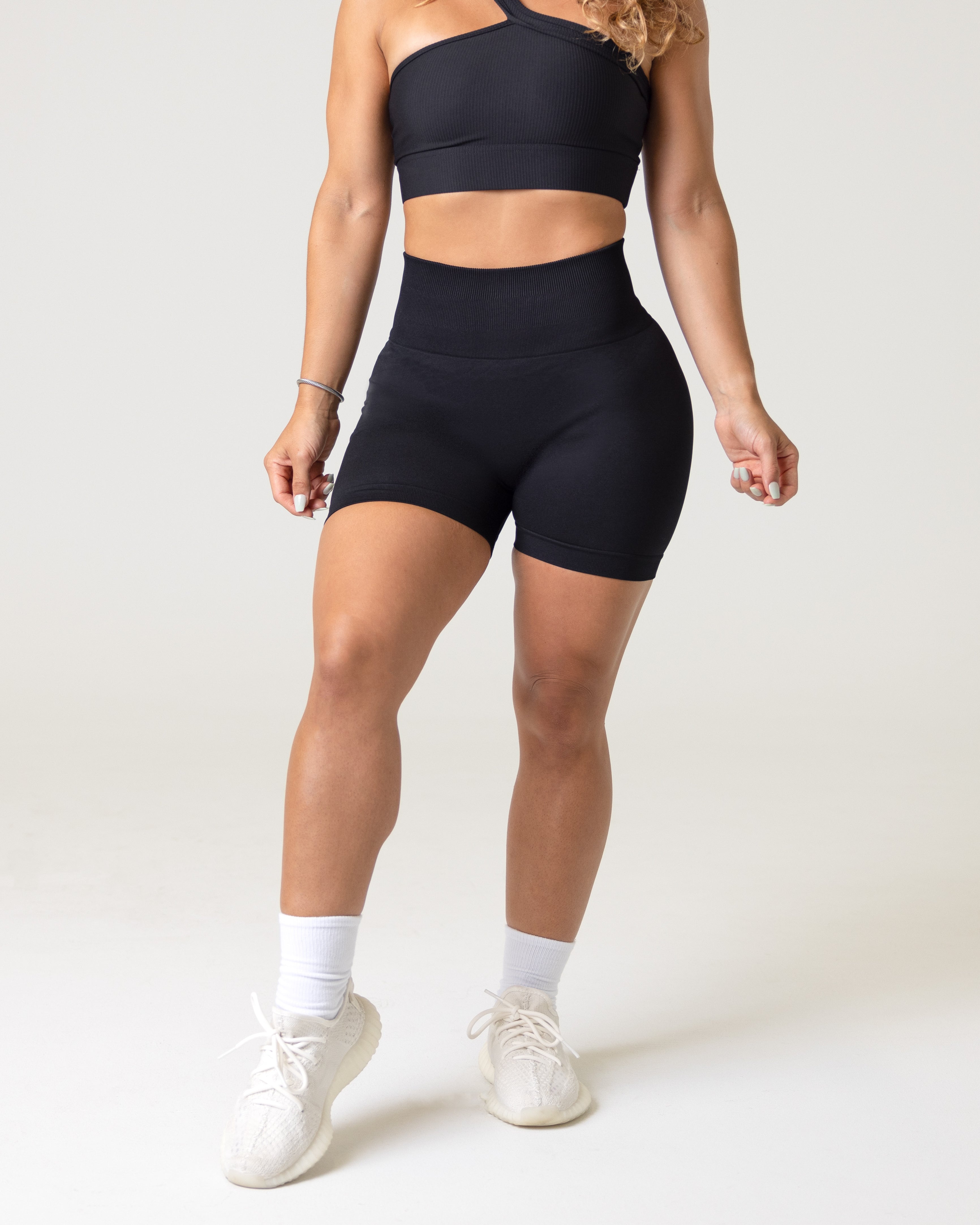A woman wearing black activewear- workout shorts